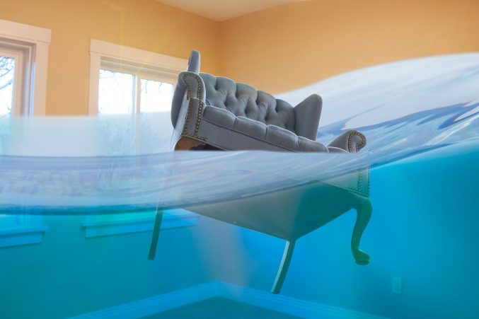 Sofá flotando en una vivienda inundada Sofá flotando en un salón inundado: vaciado por inundaciones en Madrid
